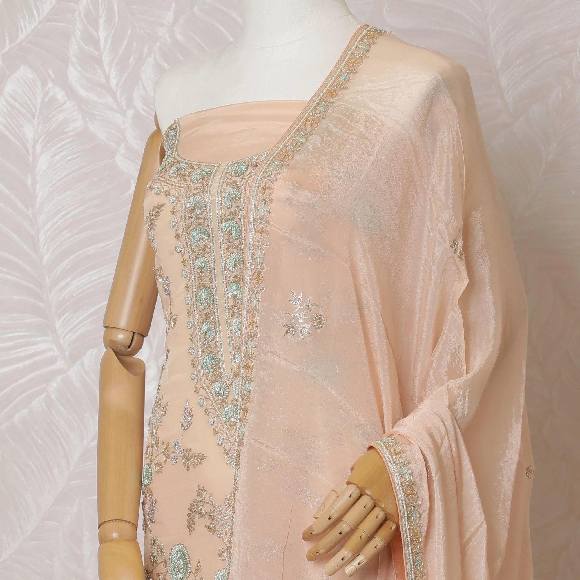 Light peach Premium pure silk crepe kameez with mint green embroidery, sequin work and stone work in floral design. Light peach plain salwar with same tone chiffon dupatta with same tone embroidery and bead work-D15577