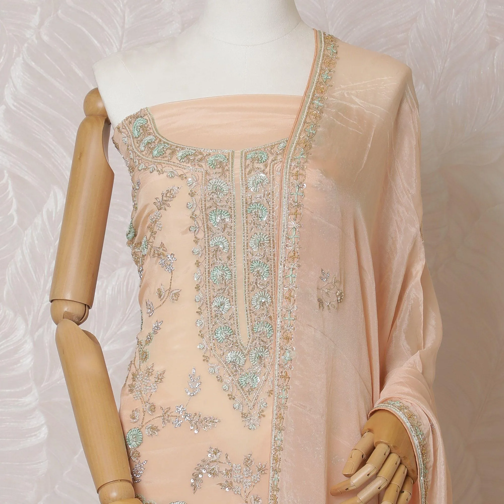Light peach Premium pure silk crepe kameez with mint green embroidery, sequin work and stone work in floral design. Light peach plain salwar with same tone chiffon dupatta with same tone embroidery and bead work-D15577